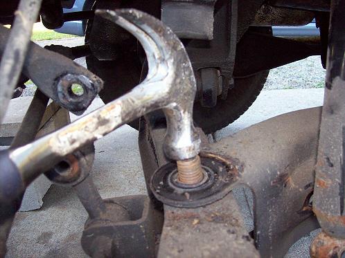 Drive the radius arm mounting bolt out of the beam with a hammer