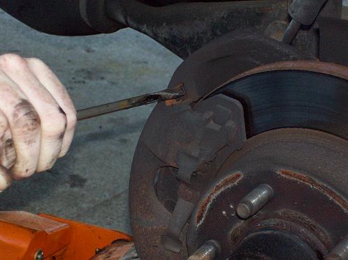 Knock the slide pins out of the brake calipers