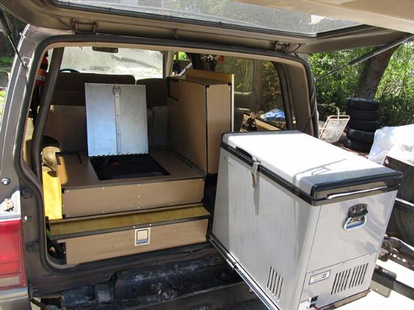 A 12-volt refrigerator sits on a slide platform to allow full access into it