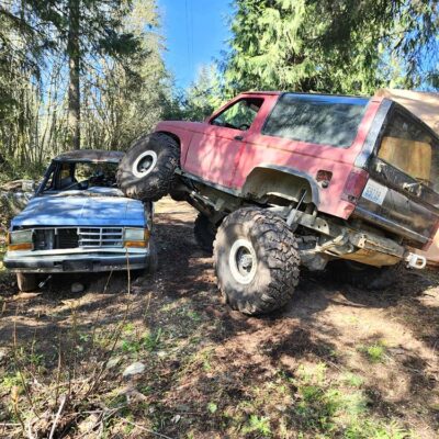 Hell Boy Ford Bronco II climbing over a Ford Ranger